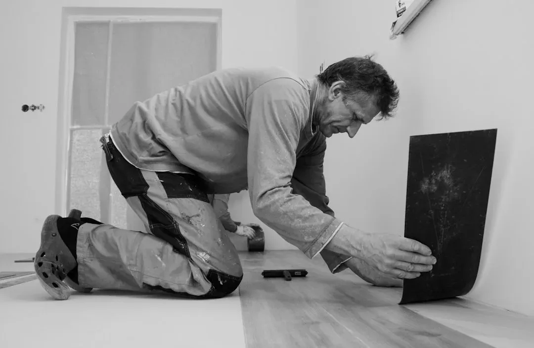 Handwerker beim Verlegen eines Bodenbelags