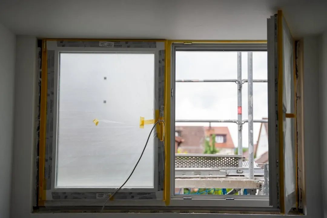 Neu eingebautes Fenster mit Schutzfolie und geöffnetem Flügel